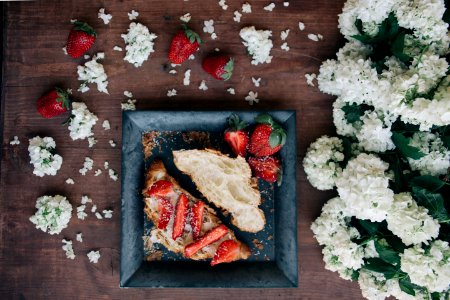 strawberry sandwich served on white plate beside white flowers photo