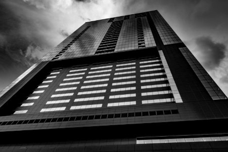 low angle and grayscale photo of high-rise building photo