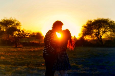 silhouette photography of couple kissing in the middle of the field photo