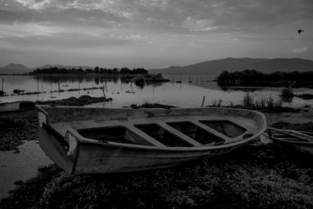 grayscale photo of boat on lake photo
