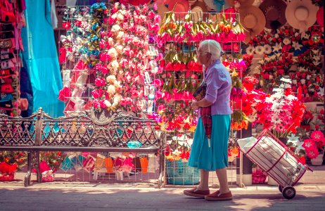 woman in pink long sleeve shirt and blue skirt standing on street with red and white photo