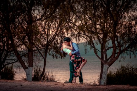 couple kissing in front of trees