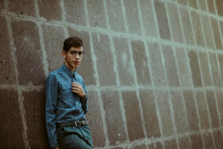 man leaning on wall photo