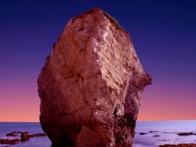 brown rock formation with body of water photo