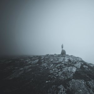 person standing on rock on top of hill photo