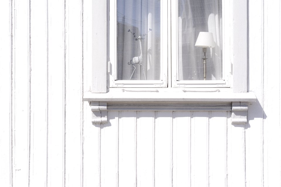 white wooden wall cabinet with figurine and table lamp inside photo