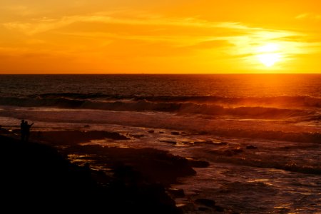 ocean waves crashing on shore during sunset photo