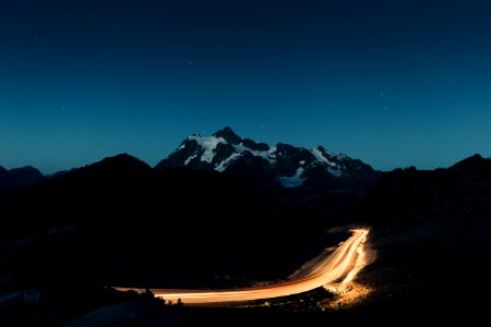 snow covered mountain under blue nightime sky photo