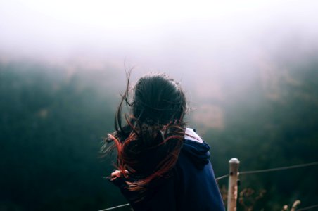 landscape photography of woman standing in front of trees photo