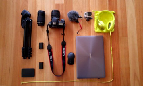 A flatlay image of photography equipment, headphones and a laptop on the floor. photo