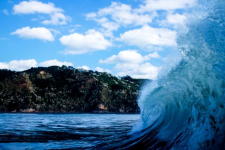 close-up photography of sea wave under white clouds and blue sky photo