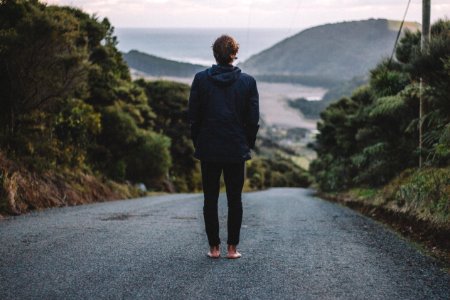 man standing on road near river photo