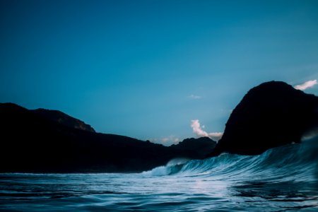 body of water near mountains at nighttime
