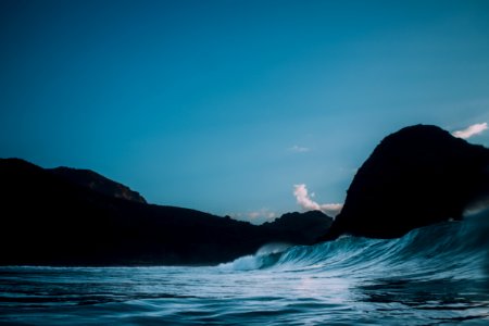 body of water near mountains at nighttime photo