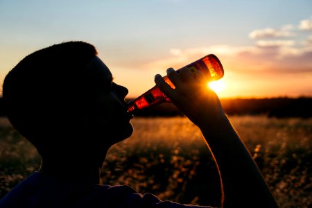 man holding glass bottle photo