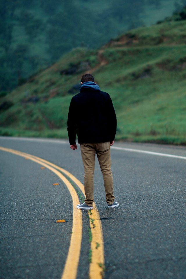 man standing on road