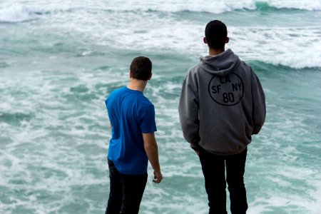 two men standing near body of water