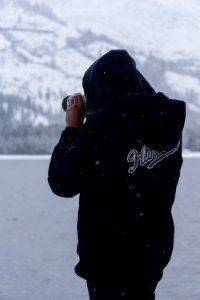 man wears hoodie takes picture during winter photo