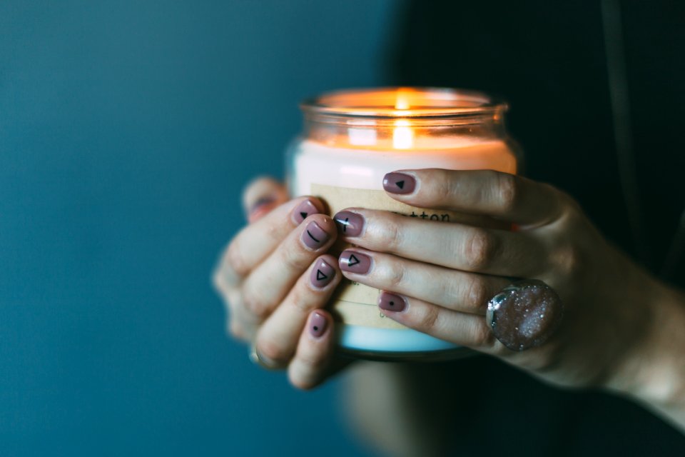 person holding white candle with light