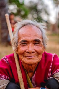man holding brown stick smiling