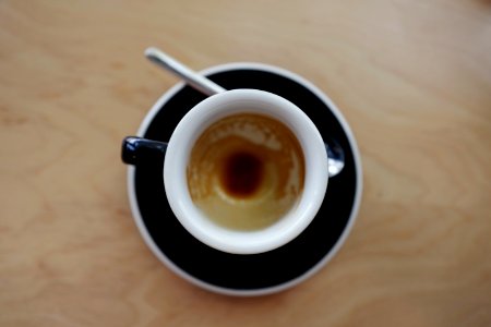 coffee in mug on saucer beside spoon photo