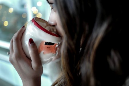woman drinking on white and red ceramic mug photo