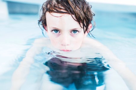 selective focus photography of boy floating on water photo
