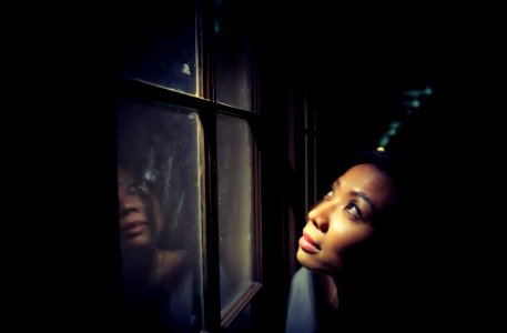 woman looking up behind window