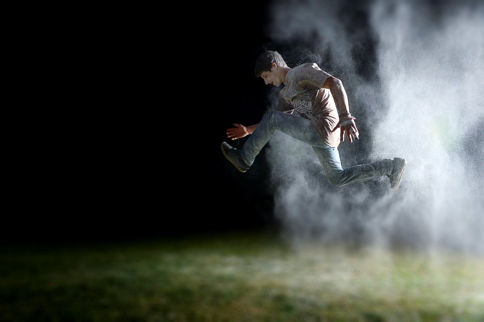 man in gray shirt jumping during night time
