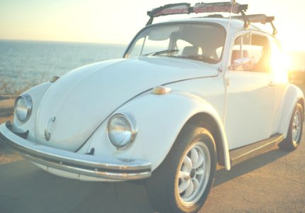 white Volkswagen Beetle on road at daytime photo