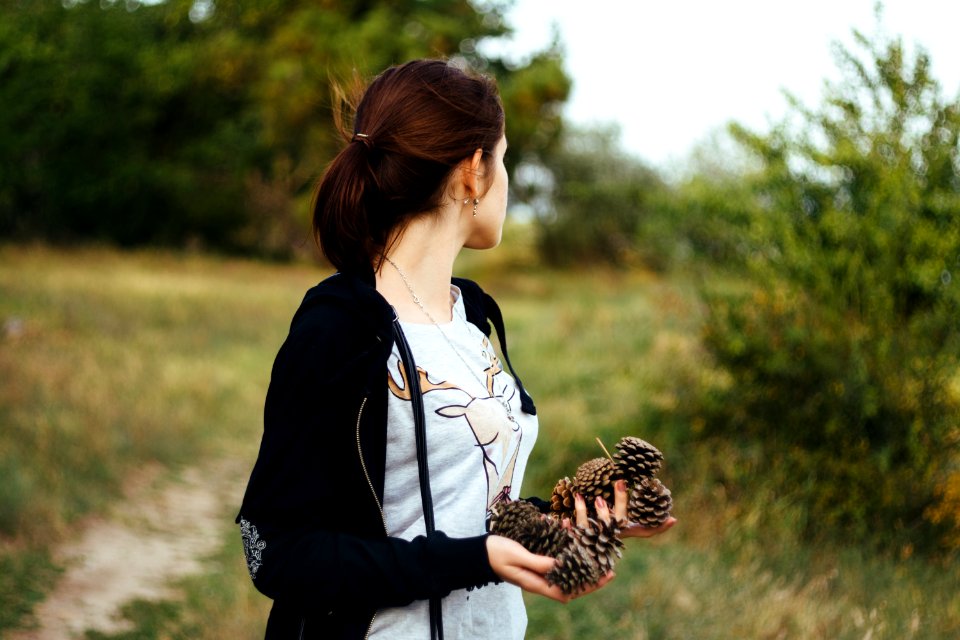 woman holding pinecones