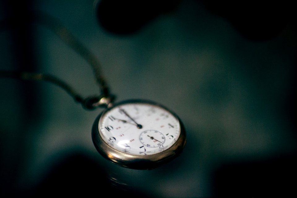 lowlight photography of white pocket watch