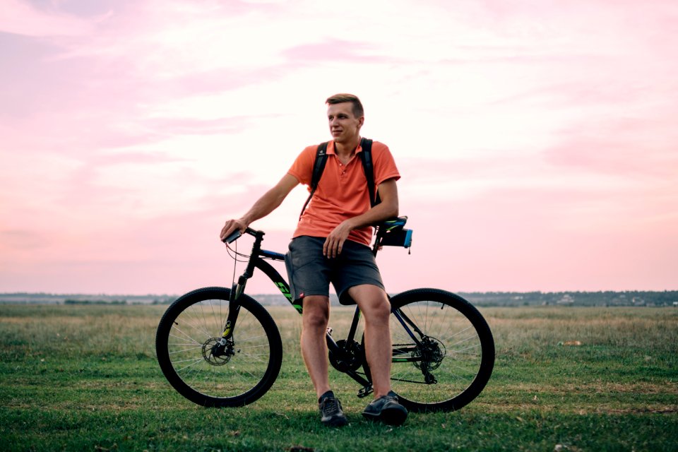 man sitting on hardtail bike under golden hour