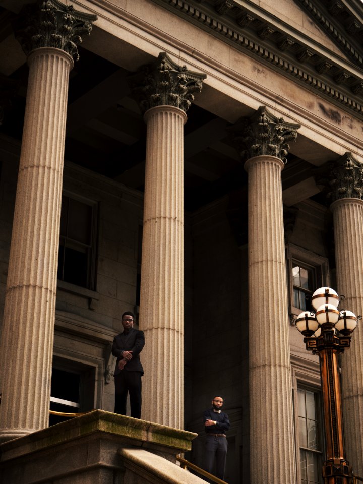 two men standing on Corinthian column building