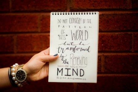 A piece of paper that reads "Do not conform to the pattern of this world but be transformed by the renewing of your mind." photo