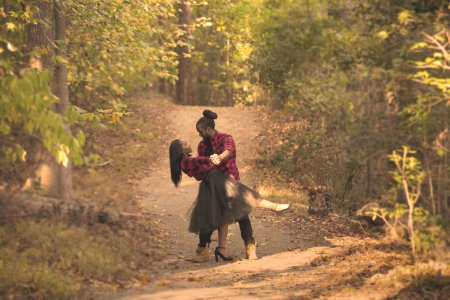 A couple standing in a nature trail embracing each other.