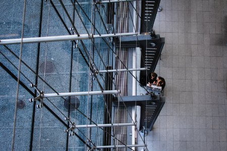 aerial photography of man and woman sitting near gray metal pillars