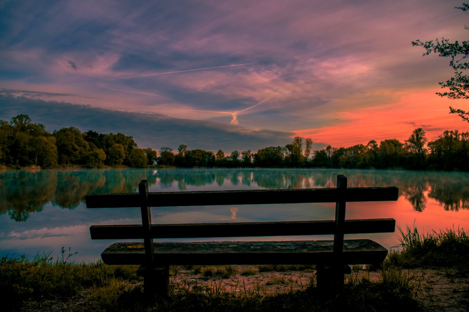 brown wooden bench near lake during daytime