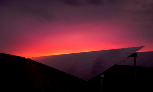 black solar panel under red and gray clouds