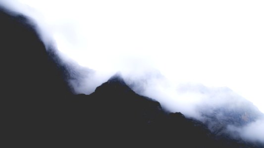 silhouette of mountain covered with fogs at daytime