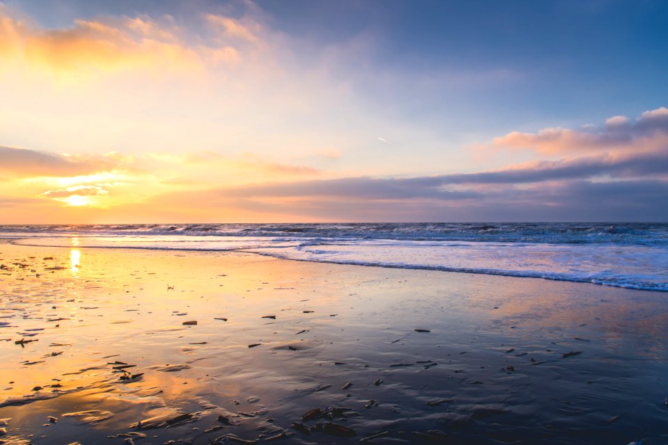 sea waves crashing on shore during sunset