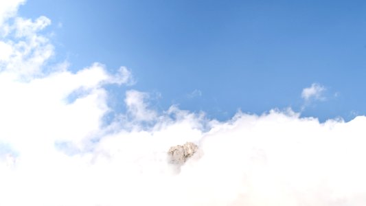 mountain between clouds