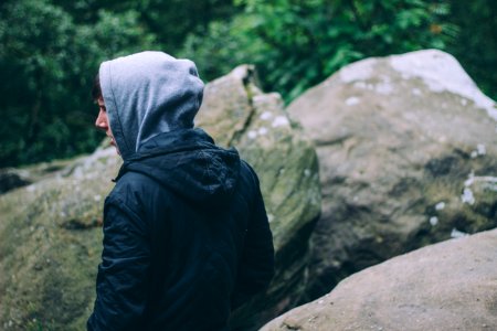 person in black hoodie near gray rocks photo