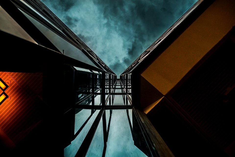 low angle photography of high-rise building under blue clouds