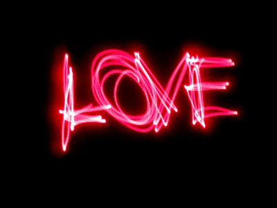 A pink neon light painting that says "Love." photo