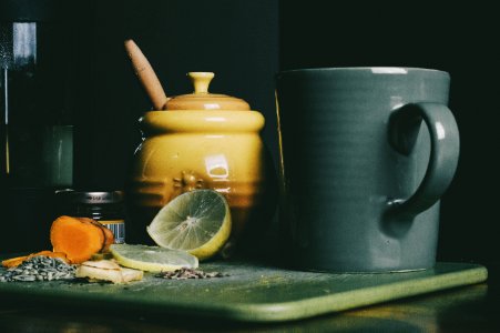 beige ceramic jar beside grey ceramic pitcher and sliced lemon fruit photo