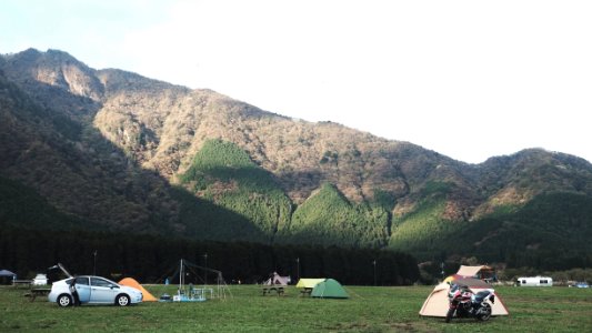 assorted-color dome tents near mountains under white clouds during daytime photo