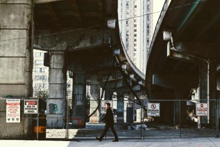 person walking under city bridge photo