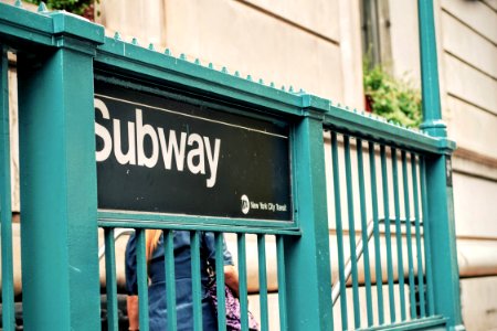 Subway signage on cyan metal fence photo