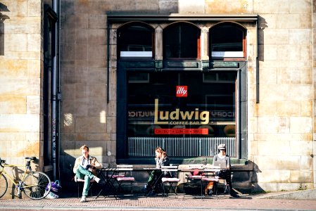 three person sitting on outdoor chair in front Ludwig cafe photo